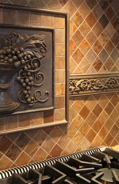 a tile backsplash in a kitchen with an ornate design on the back splash