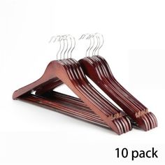 three wooden hangers with clips on each side and one is holding two pairs of clothes