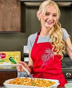 a woman in an apron holding a plate of food