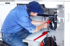 a plumber working on a sink with tools