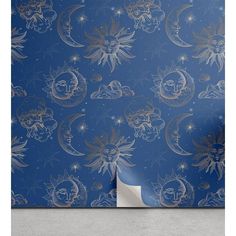 a blue wallpaper with gold stars and moon designs on it, against a concrete floor