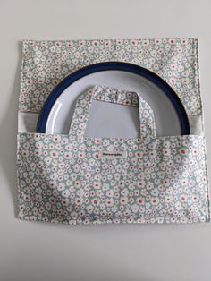 a blue and white bag sitting on top of a table next to a plate in front of it