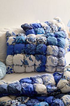 several blue and white pillows stacked on top of each other