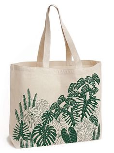 a white tote bag with green leaves on the front and bottom, sitting against a white background