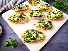 several pieces of bread with spinach on top