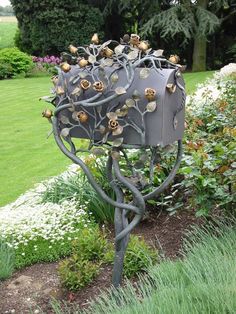 a metal sculpture in the middle of a garden