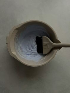 a bowl filled with white paint and a brush