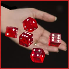 four red dices being held in the palm of a person's outstretched hand