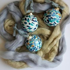 three ornaments are sitting on top of some yarn