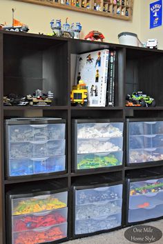 a shelf filled with lots of plastic containers and toy cars on top of it's shelves