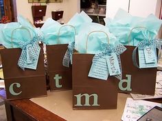 three brown bags with blue bows and letters on them