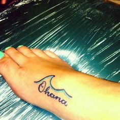 a woman's foot with the word ohana written on it and an arrow tattoo