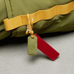 a green bag with a red tag attached to it