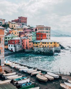 boats are parked on the shore in front of colorful buildings