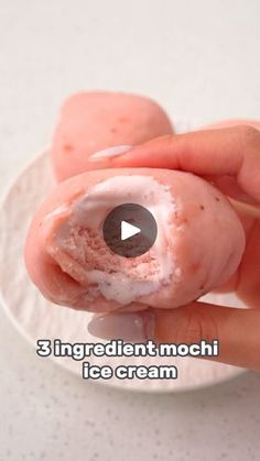 a person holding a donut with icing on it in front of the camera