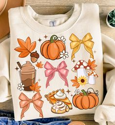 a white shirt with various fall items on it, including shoes and an orange bow