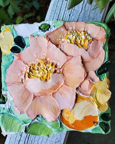 a close up of a cake decorated with flowers on top of a piece of wood