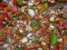 a pot filled with lots of different types of vegetables and sauce on top of it