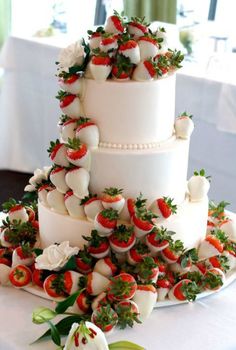 a wedding cake with strawberries and flowers on it