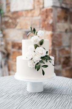 a white wedding cake with flowers on top