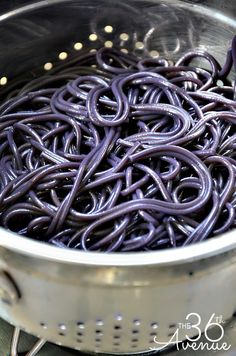 a pot filled with purple noodles on top of a stove