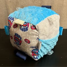 a blue and white backpack sitting on top of a black table next to a wall