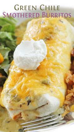 green chile smothered burritos and rice on a plate with a fork