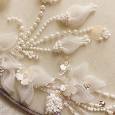 white flowers and pearls are attached to the fabric