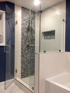 a bathroom with a walk in shower next to a white bath tub and blue walls