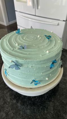 a blue cake sitting on top of a counter next to a white refrigerator freezer