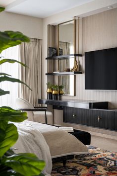 a living room filled with furniture and a flat screen tv mounted on a wall next to a window