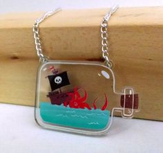 a glass necklace with an octopus and pirate ship in the ocean on it's side