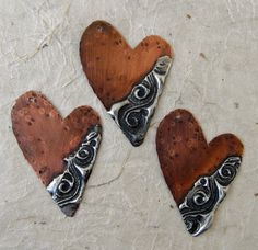 three wooden heart shaped magnets sitting on top of a table