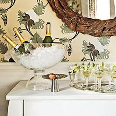 a table topped with wine glasses filled with champagne next to a wallpapered mirror