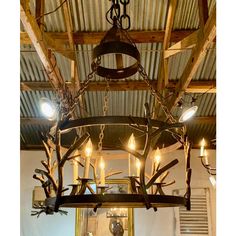 a chandelier hanging from the ceiling in a room with wooden beams and lights