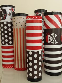 several different colored paper cups are lined up on a table with polka dots and stripes