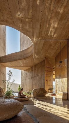 a person sitting in a room with large rocks