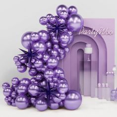 purple balloons are arranged in the shape of an arch with stars on it and next to a greeting card