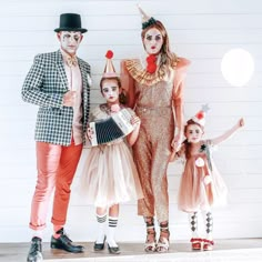 three adults and two children dressed up as clowns