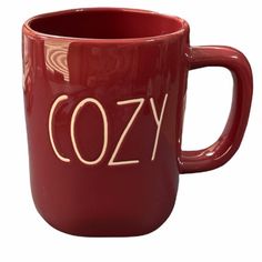 a red coffee mug with the word cozy printed on it's front and side