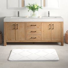 a bathroom vanity with two mirrors above it and a rug on the floor in front of it