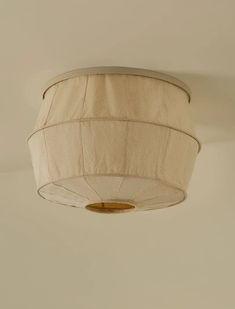 a white ceiling light with a beige shade