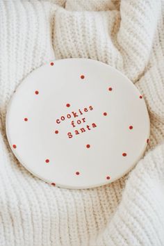 a white plate with red dots on it that says cookies for santa in small letters