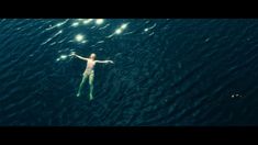 a man swimming in the ocean with his arms outstretched