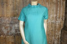 "Fab vintage mod cocktail dress dating from 1960s. Made from a substantial satin back crepe fabric in a jade green collar, it`s just above knee length, with short sleeves. It has a stunning Bardot neckline, trimmed with embroidery and tiny pearl beads. Fully lined, fastens with a metal zip at the back. Measures 42\" bust, 38\" waist, 44\" hips. Length 38\" from shoulder to hem. Please check all measurements carefully- if possible, compare them to a dress of your own. It has some condition issues, with faint bluish marks, mainly on the sides and sleeves. It has some rust coloured marks on the collar, with one or 2 of the beads missing. Otherwise good." Retro Short Sleeve Cocktail Dress, Green Short Sleeve Mini Dress For Formal Occasions, Formal Green Short Sleeve Mini Dress, 60s Mod Dress, Mod Dress 60s, Bardot Neckline, Mod Vintage, Collared Greens, 60s Mod