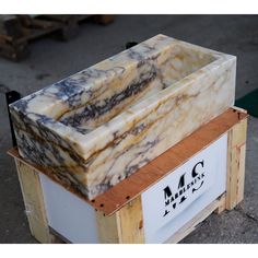 a marble sink sitting on top of a wooden crate