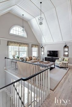 a living room filled with furniture and a fire place in the middle of an open floor plan