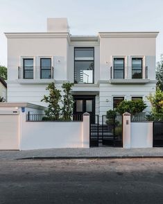 a large white house with black gate and windows