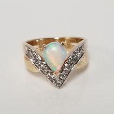 "Thanks for shopping our vintage estate store. We tend to sell well below wholesale and truly hope you enjoy all of our items. Many of the items are one of a kind, so please enjoy scrolling through the pictures and hopefully something will catch your eye. Brown spots are from the camera or reflections. Estate 14k yellow gold natural fire 1.5ct opal .50ct diamond ring. There are 9 diamonds and they are nice and bright. Ring size: 6 Setting: 1/4\" 7mm by 11mm 1/2\" Gem: 9mm by 6.5mm Band width: 4m Fine Jewelry Opal Ring With Multi-stone For Anniversary, Yellow Gold Multi-stone Opal Ring For Anniversary, Heirloom Multi-stone Opal Ring For Anniversary, Vintage Hallmarked Opal Ring For Anniversary, Oval Opal Ring Stamped 14k For Anniversary, Pear-shaped Vvs Clarity Rings For Anniversary, Pear-shaped Multi-stone Diamond Ring For Anniversary, Anniversary Opal Ring Stamped 14k In Oval Shape, Pear-shaped Multi-stone Diamond Anniversary Ring