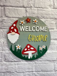 a welcome gnome sign on a white brick wall